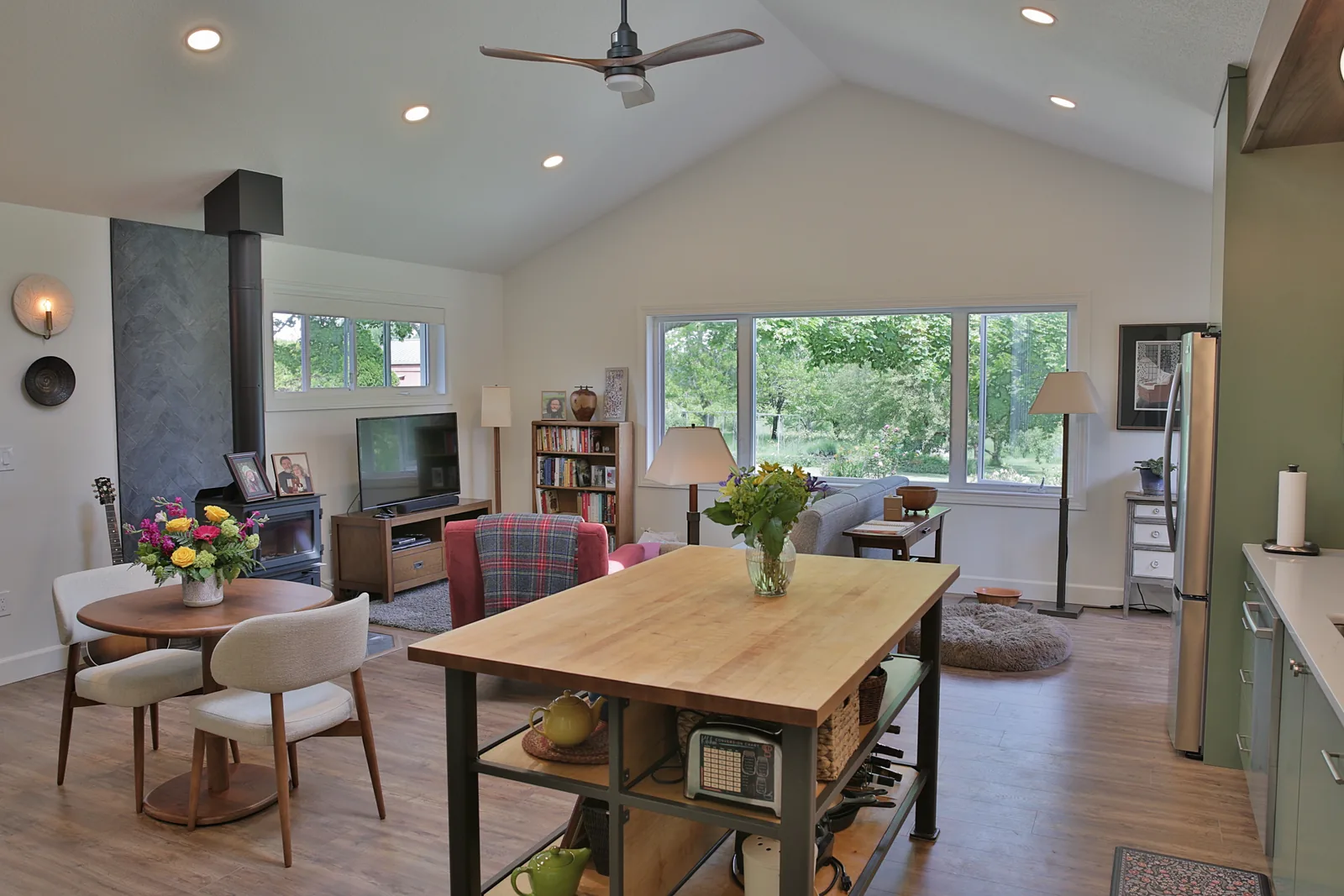 Vaulted great room with wood stove and ProVia windows looking onto the property
