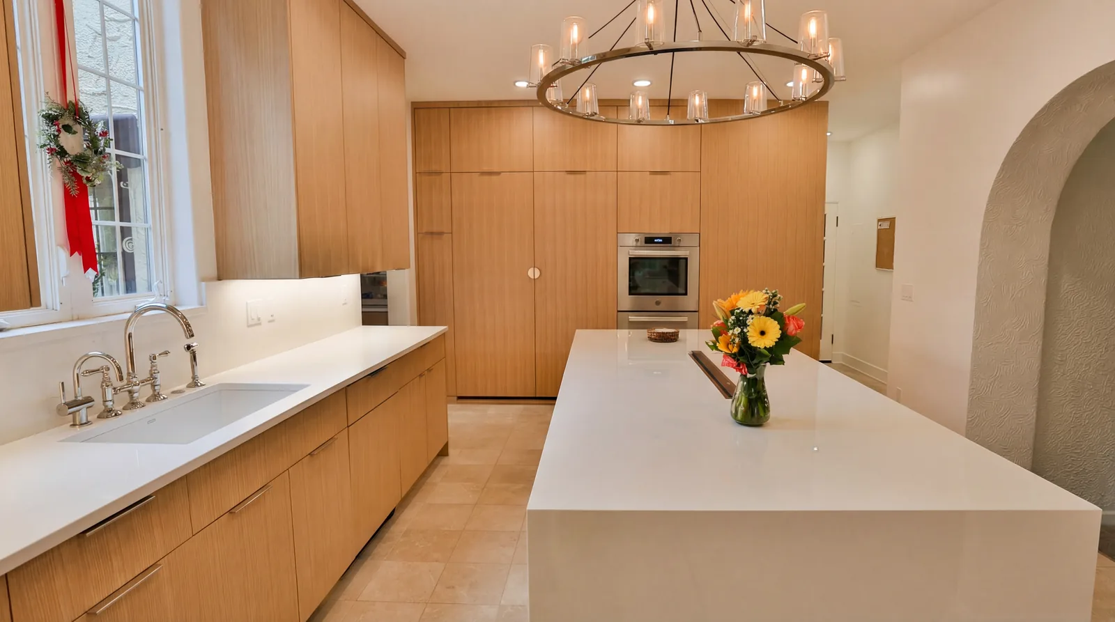Rift white oak flat-panel cabinetry with stone backsplash and undercabinet lighting