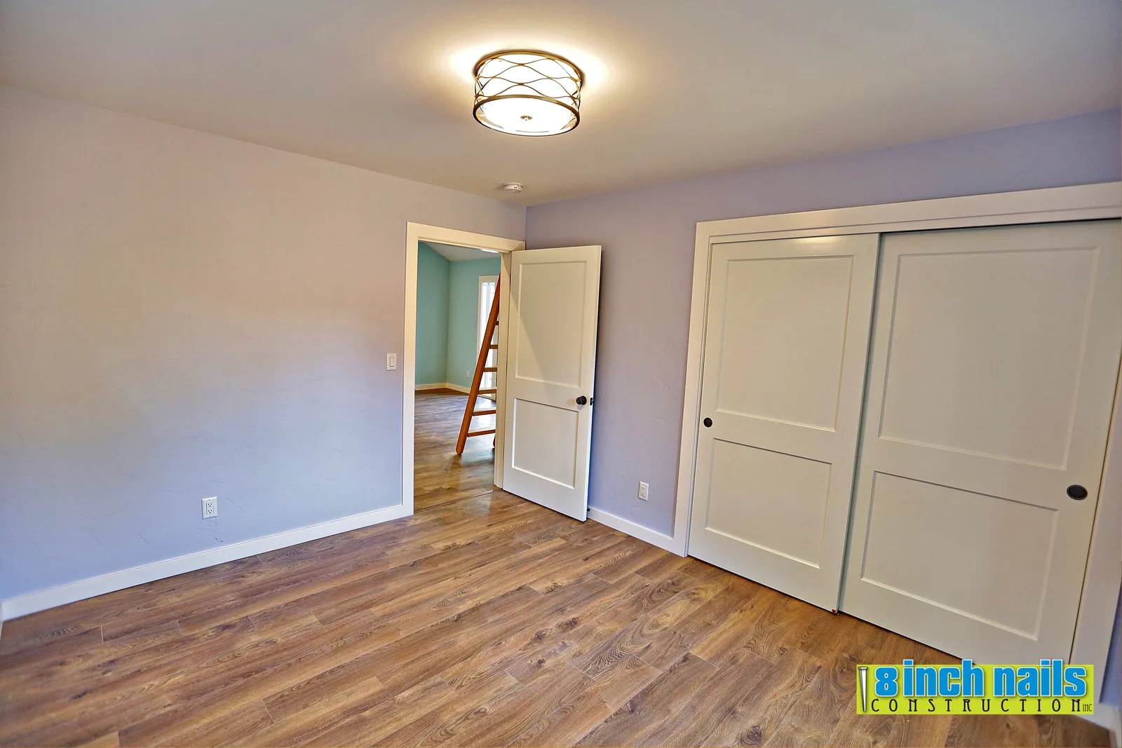 ADU bedroom with sliding closet doors and luxury vinyl plank flooring