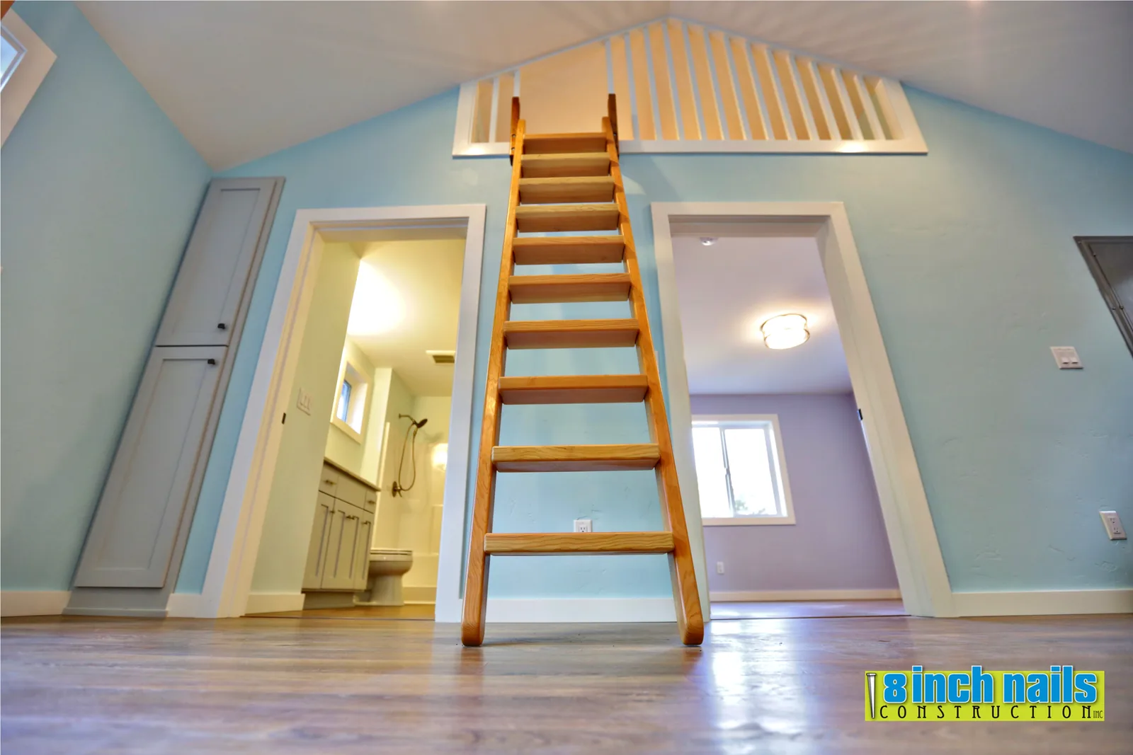 Wood ship's ladder to the loft, with the full bath and bedroom off the great room